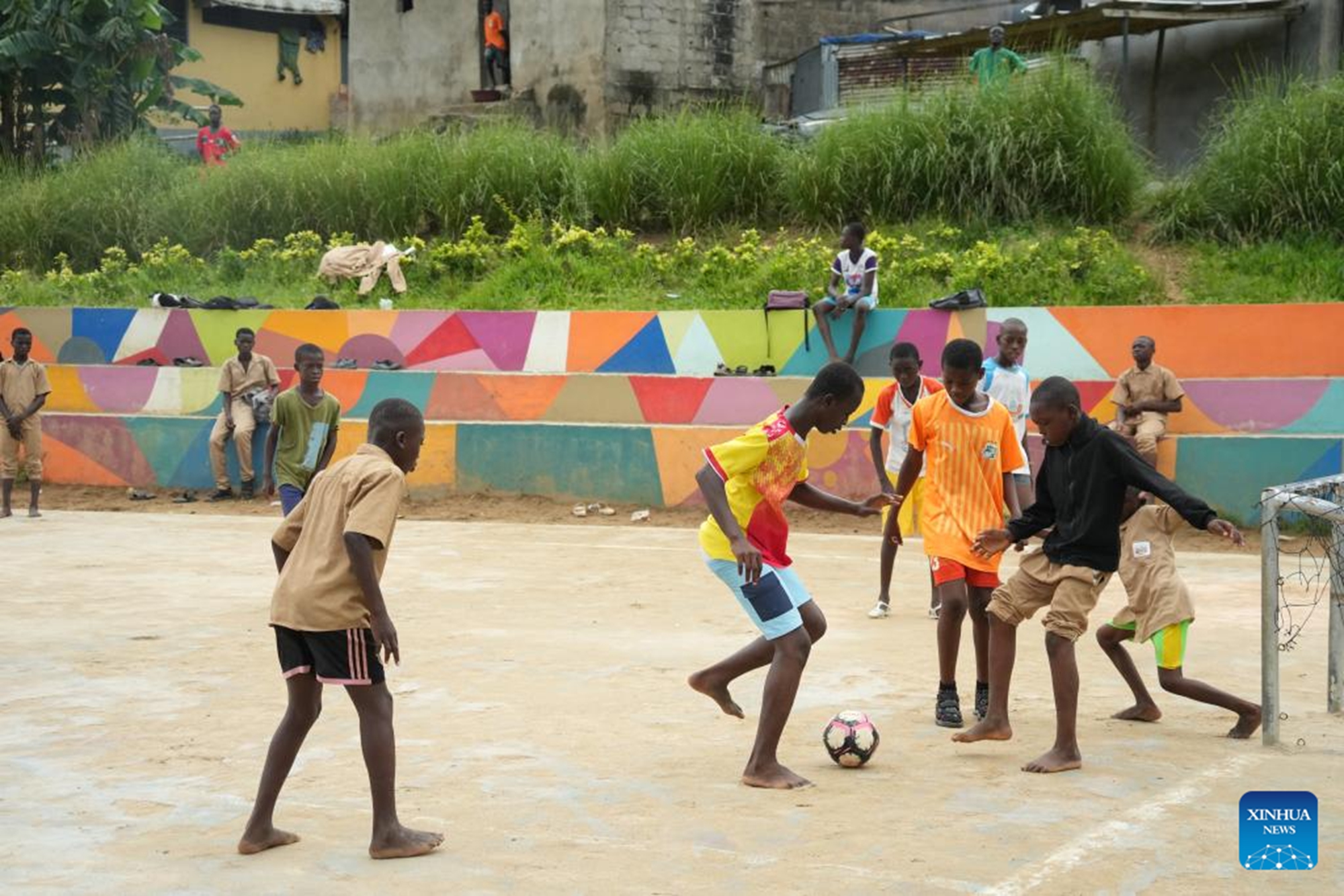 Boys play football at a football field along a newly-built drainage channel in the Abobo commune in northern Abidjan, Cote d'Ivoire, April 22, 2026. TO GO WITH Feature: Chinese-built drainage project transforms Cote d'Ivoire's flood-prone commune (Xinhua/Zhang Jian)

