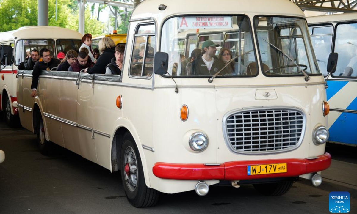 People ride a vintage bus in Warsaw, Poland, on May 16, 2026. Vintage bus-riding event in Warsaw attracts residents and tourists to experience the history of public transportation. (Photo by Jaap Arriens/Xinhua)