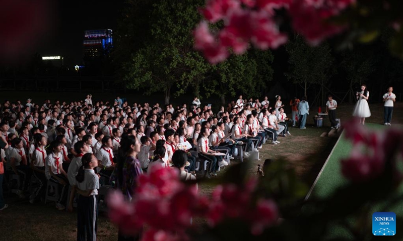Sixth-grade students watch a video featuring memories of their school life during a graduation camping night event at a school in Wuchang District of Wuhan, central China's Hubei Province, May 15, 2026. The school held the event here on Friday for more than 300 sixth-grade students who are about to graduate. (Xinhua/Xiao Yijiu)