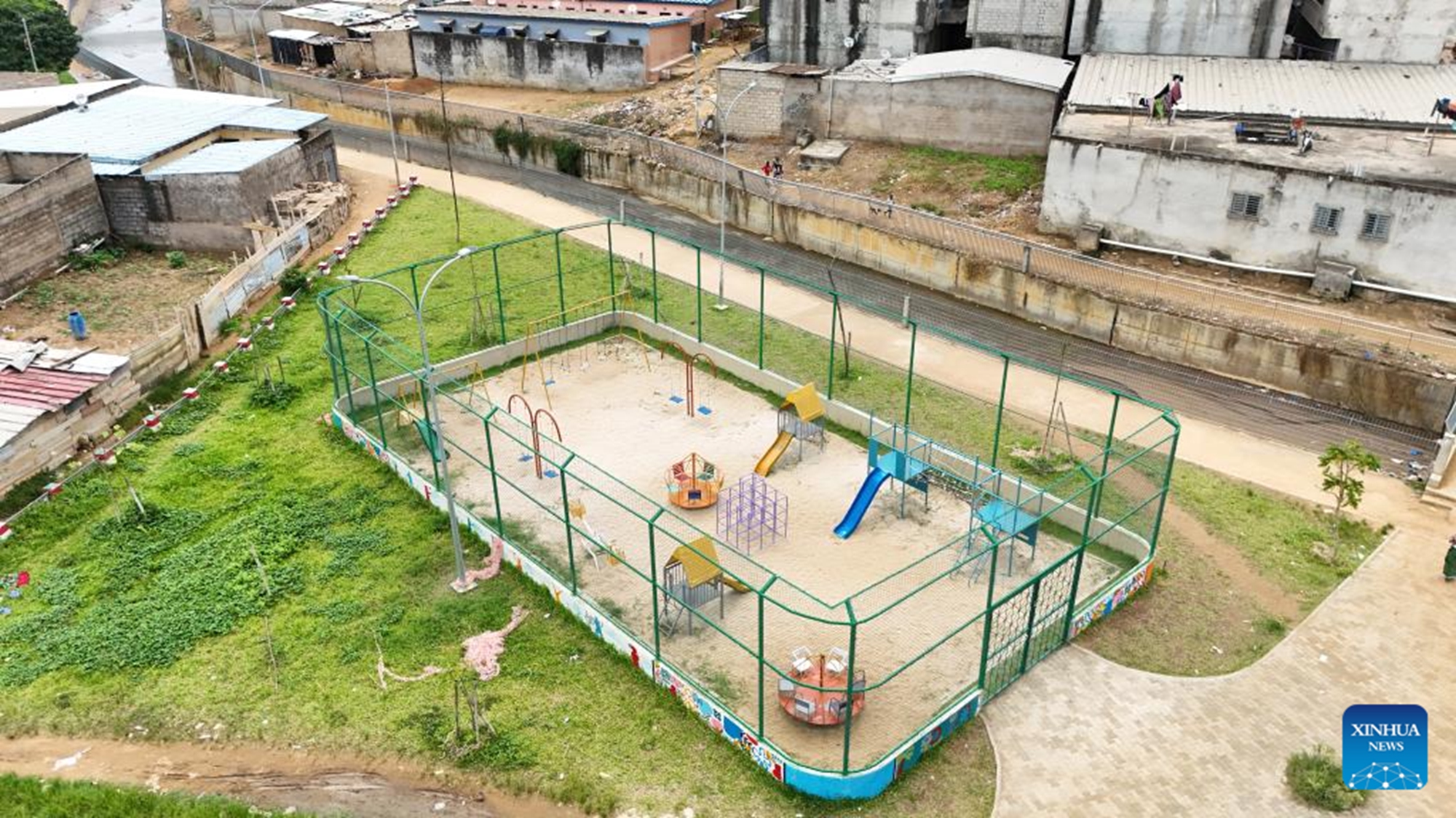 An aerial drone photo taken on April 22, 2026 shows a children's playground along a newly-built drainage channel in the Abobo commune in northern Abidjan, Cote d'Ivoire. TO GO WITH Feature: Chinese-built drainage project transforms Cote d'Ivoire's flood-prone commune (Power Construction Corporation of China/Handout via Xinhua)

