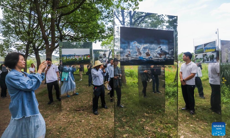 People view an open air art exhibition in Zhijiang Village of Xiaya Town, Jiande City of east China's Zhejiang Province, May 16, 2026. A photography + oil painting dual art exhibition was unveiled in Zhijiang Village of Xiaya Town on Saturday. Breaking the conventional boundaries of traditional art galleries, the exhibition is set amid fields, forests, and village paths. A total of 90 photography and oil painting works showcased the local rural customs and landscapes, with the majority of the artists being local villagers. Photo: Xinhua