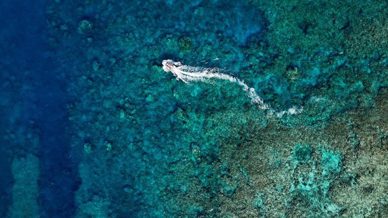 An aerial drone photo taken on April 24, 2026 shows a boat deployed by the China Coast Guard (CCG) vessel Chuanshan patrolling near a reef in the territorial waters of China's Huangyan Dao in the South China Sea. (Xinhua/Chen Bin)