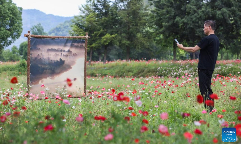 A man views an open air art exhibition in Zhijiang Village of Xiaya Town, Jiande City of east China's Zhejiang Province, May 16, 2026. A photography + oil painting dual art exhibition was unveiled in Zhijiang Village of Xiaya Town on Saturday. Breaking the conventional boundaries of traditional art galleries, the exhibition is set amid fields, forests, and village paths. A total of 90 photography and oil painting works showcased the local rural customs and landscapes, with the majority of the artists being local villagers. Photo: Xinhua
