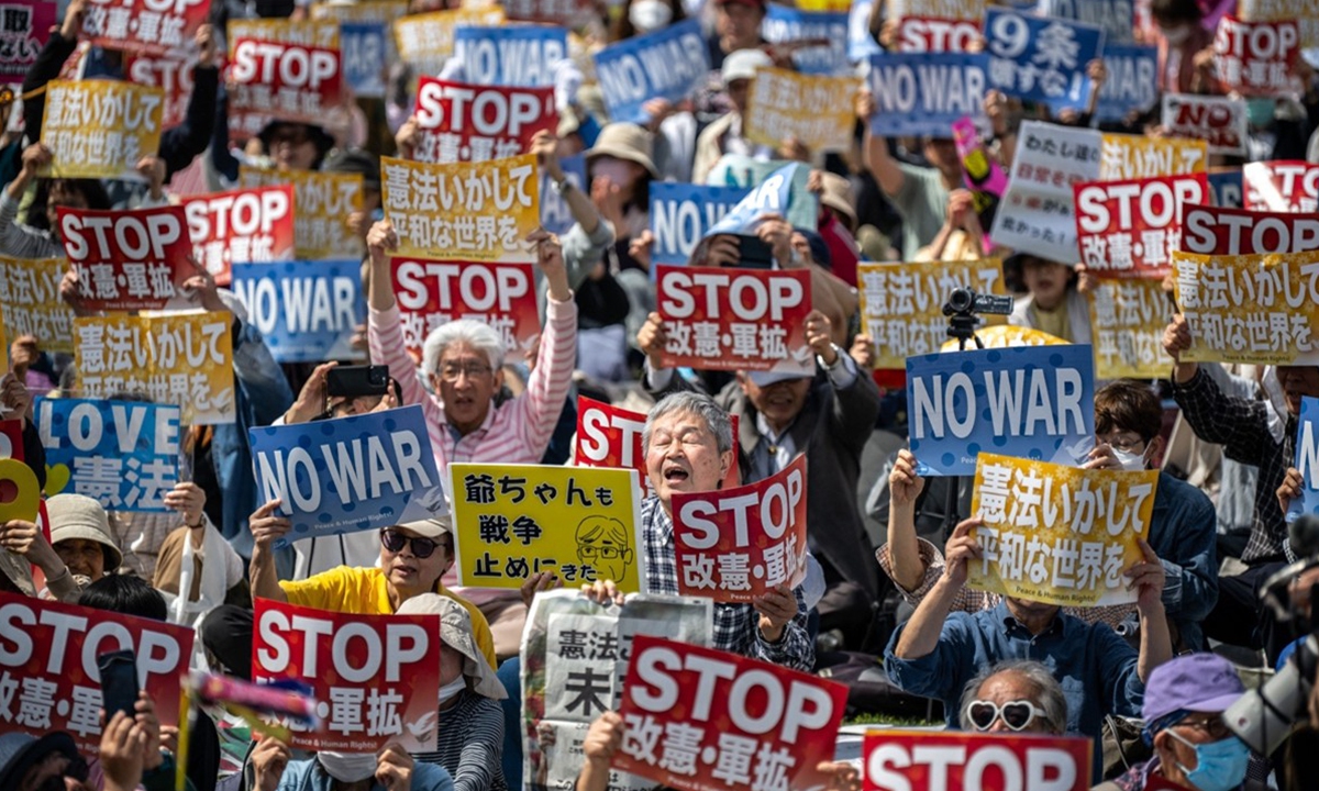People hold placards reading 