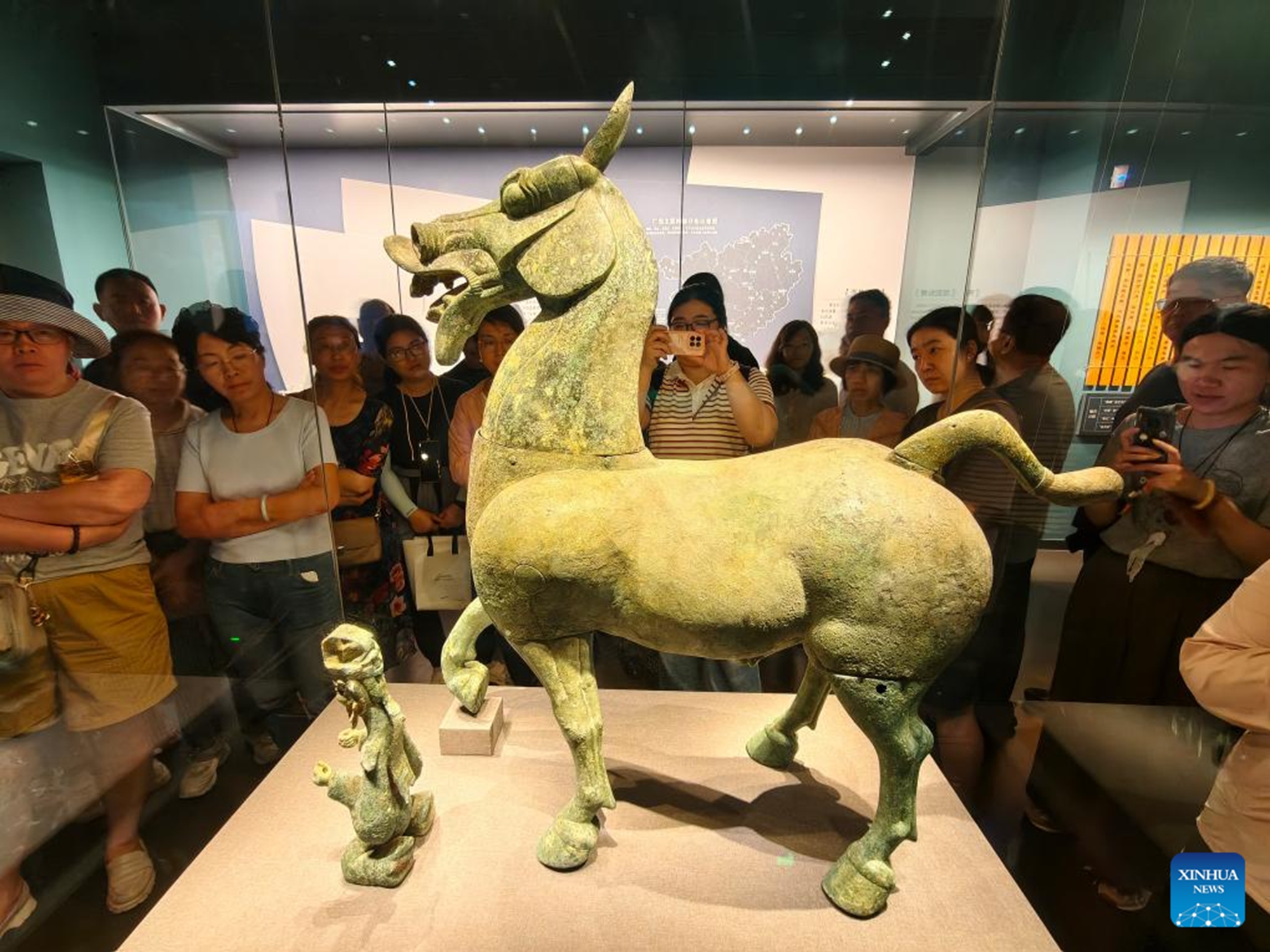 People look at a cultural relic on display at the Museum of Guangxi Zhuang Autonomous Region in Nanning, south China's Guangxi Zhuang Autonomous Region, May 16, 2026. Museums across China receive large numbers of visitors with the upcoming International Museum Day, which will fall on May 18. (Photo by Yu Xiangquan/Xinhua)