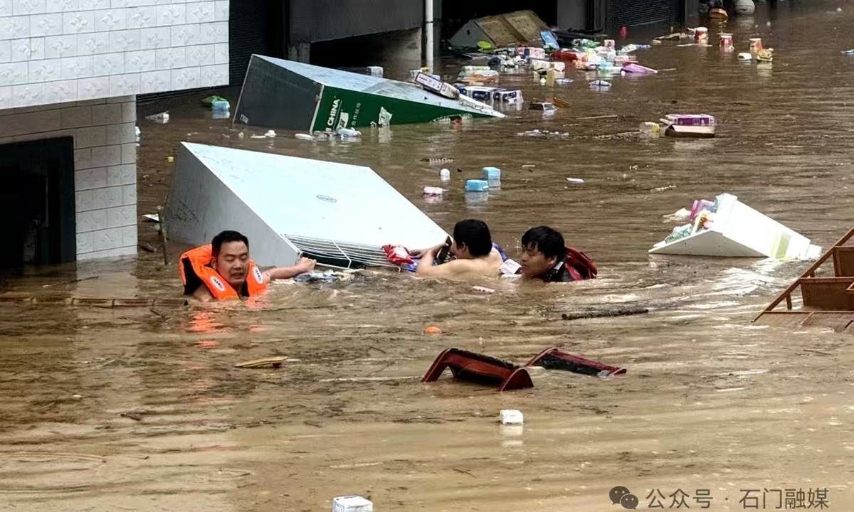 Village officials in Hupingshan town help evacuate residents from dangerous areas. Photo: official WeChat account of Shimen County authorities.