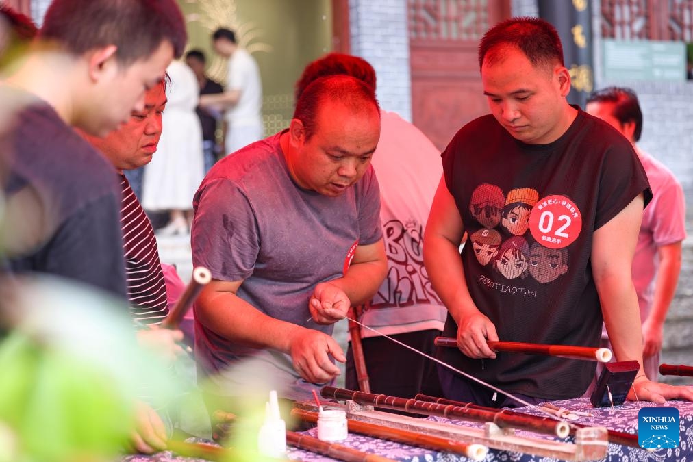 Contestants are in action during a bamboo flute making skills competition at Yuping Bamboo Flute Museum in Yuping Dong Autonomous County, southwest China's Guizhou Province, May 18, 2026. The competition was held here on Monday to mark the International Museum Day. The Yuping bamboo flutes, made from a kind of local bamboo, are well-known traditional wind instruments in China. The making technique of these flutes was included in the first batch of the National Intangible Cultural Heritage List in 2006. (Photo: Xinhua)