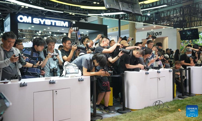 Visitors try cameras at the exhibition area of Nikon at the 27th China International Photograph & Electrical Imaging Machinery and Technology Fair (China P&E) at the Beijing Exhibition Center in Beijing, capital of China, May 18, 2026. The 27th China International Photograph & Electrical Imaging Machinery and Technology Fair (China P&E) concluded here on Monday. With an exhibition area of more than 20,000 square meters, the event gathered more than 120 exhibitors, covering a full range of imaging gear including camera, lens, lighting equipment, storage device and others. (Photo: Xinhua)