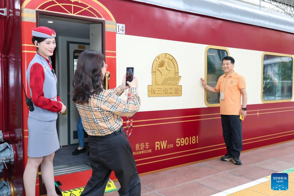 A passenger takes a photo before boarding the Delta Star Express in east China's Shanghai, May 19, 2026. The Delta Star Express, a tourist train featuring cozy accommodations, departed Tuesday from Shanghai, carrying nearly 200 passengers for an 18-day tour to northwest China's Xinjiang Uygur Autonomous Region. Developed by China Railway Shanghai Group Co., Ltd., the tourist train provides multi-passenger cabins with in-suite bathrooms, storage spaces as well as panoramic viewing windows. (Photo: Xinhua)