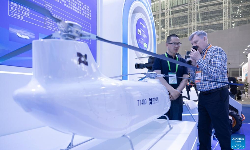 A participant gets to know a product of United Aircraft during the 10th China-Russia Expo in Harbin, northeast China's Heilongjiang Province, May 18, 2026. With a total exhibition area of 55,000 square meters, this year's expo has attracted more than 1,500 enterprises from 46 countries and regions. It also features nearly 100 supporting events covering industrial matchmaking, investment promotion, international cooperation, tourism and consumption. (Photo: Xinhua)