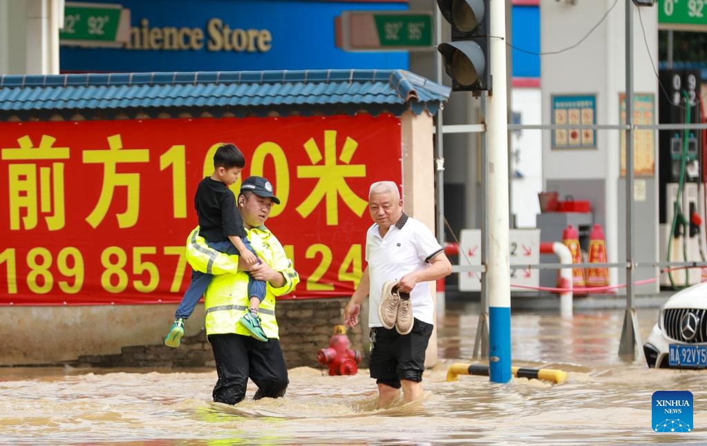 A police officer holds a boy as he wades through a flooded street in Duyun City, southwest China's Guizhou Province, May 19, 2026. Heavy rains lashed Duyun City from 6 a.m. Monday to 6 a.m. Tuesday. Guizhou geological disaster prevention and control headquarters activated a Level III alert for geological disasters in the Qiandongnan, Qiannan and Qianxinan prefectures. (Photo: Xinhua)