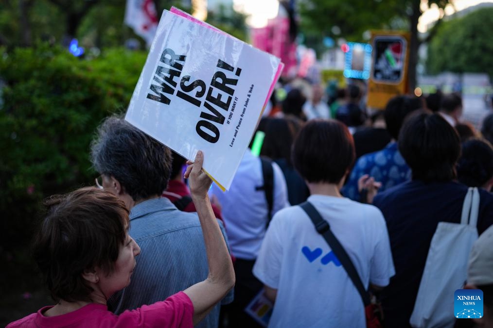 A woman holding slogans participates in a protest rally in front of the National Diet Building in Tokyo, Japan, May 19, 2026. Thousands of demonstrators gathered in front of Japan's National Diet Building in Tokyo on Tuesday evening to protest the government's attempts to undermine the country's pacifist constitution through constitutional revision and military expansion policies (Photo: Xinhua)