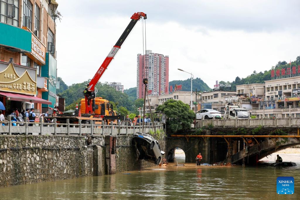 A submerged car is lifted in Duyun City, southwest China's Guizhou Province, May 19, 2026. Heavy rains lashed Duyun City from 6 a.m. Monday to 6 a.m. Tuesday. Flood control and disaster relief work are underway in flood-hit areas. (Photo: Xinhua)