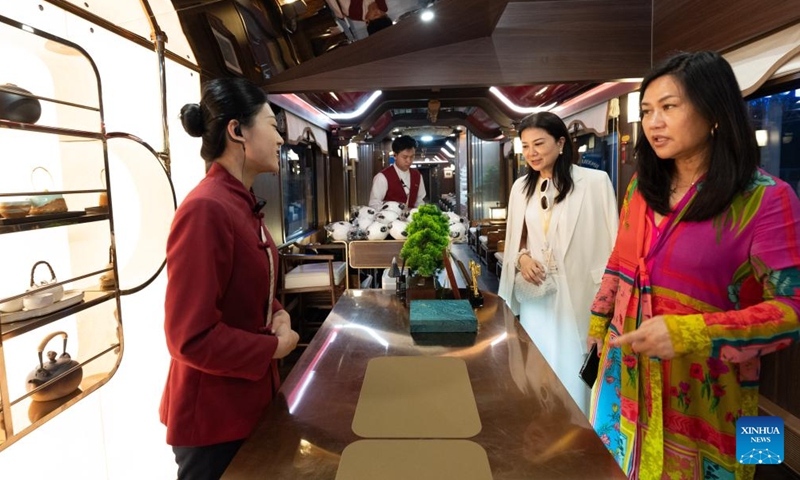 Passengers from southeast China's Taiwan inquire on tea products aboard the panda train Splendid Tianfu, at Anjing Railway Station in southwest China's Sichuan Province, May 19, 2026. The panda train Splendid Tianfu, a panda-themed tourist train, departed Tuesday from Chengdu carrying 92 passengers for a 16-day tour of northwest China's Xinjiang Uygur Autonomous Region. (Photo: Xinhua)
