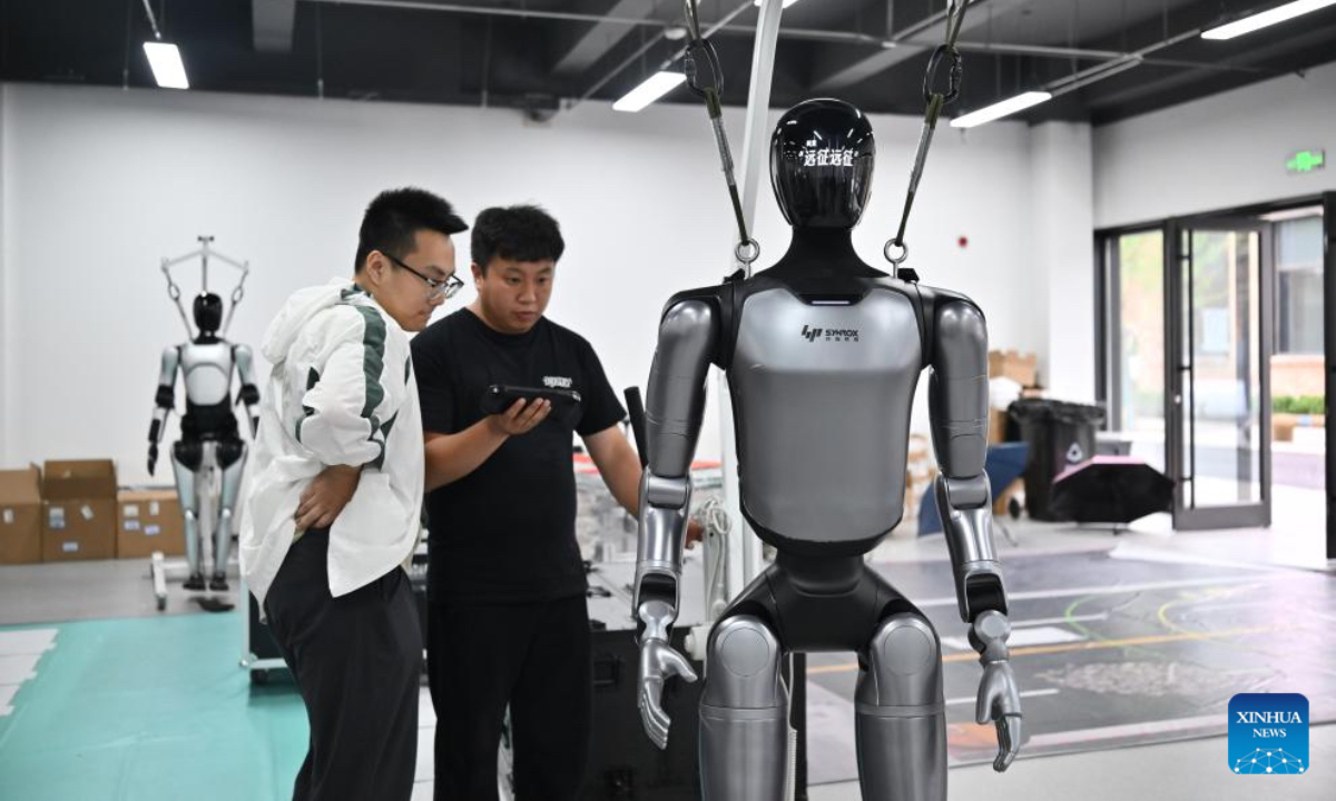 Engineers adjust a humanoid robot at tech firm SYNROX in 764 Aerospace, north China's Tianjin Municipality, May 20, 2026. Located on the site of a former state-owned broadcasting equipment factory, the 764 Aerospace, a digital industrial park in Hexi District of Tianjin, is home to more than 10 high-tech enterprises. Featuring embodied intelligence industry, the park focuses on advancing embodied intelligence data collection, robot debugging, algorithm R&D and scenario implementation, and has built a full-chain industrial cluster covering the whole process from data collection to scenario deployment. (Xinhua/Sun Fanyue)