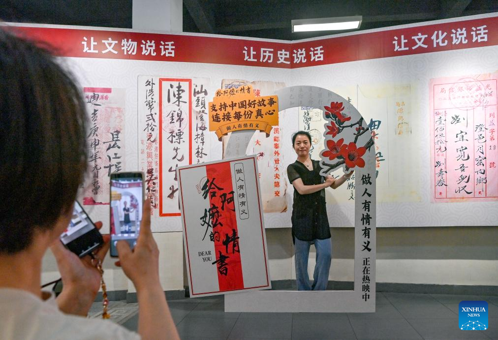 A tourist poses for photos at a museum dedicated to qiaopi in Shantou, south China's Guangdong Province, May 18, 2026. Qiaopi -- letters and remittances sent home by earlier generations of overseas Chinese -- once traveled quietly across oceans, carrying longing and news from distant lives back to families waiting in China. (Photo by Lin Peng/Xinhua)