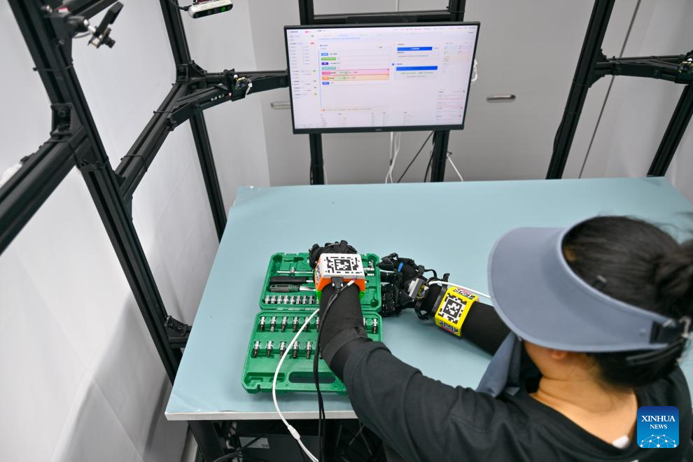 A staff member wearing sensor devices carries out data collection under industrial scenarios at Paxini Super EID Factory in 764 Aerospace, north China's Tianjin Municipality, May 20, 2026. Located on the site of a former state-owned broadcasting equipment factory, the 764 Aerospace, a digital industrial park in Hexi District of Tianjin, is home to more than 10 high-tech enterprises. Featuring embodied intelligence industry, the park focuses on advancing embodied intelligence data collection, robot debugging, algorithm R&D and scenario implementation, and has built a full-chain industrial cluster covering the whole process from data collection to scenario deployment. (Xinhua/Sun Fanyue)