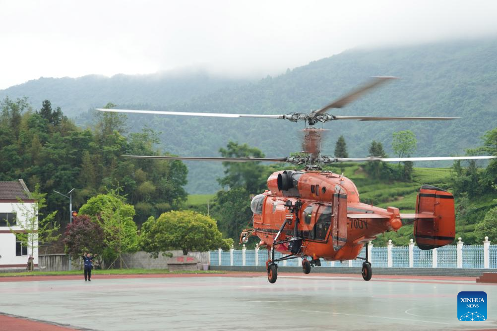 A helicopter, carrying disaster-affected villagers, lands at a school in Nanbei Town, Shimen County, Changde City of central China's Hunan Province, May 21, 2026. Recently, some areas in Hunan have been hit by severe flooding, resulting in heavy casualties and property losses. Continuous heavy rainfall has lashed the province's Shimen County, leaving six people dead and 10 others missing so far, according to local authorities. A helicopter landed at a school in Nanbei Town of Shimen County on Thursday afternoon, completing the safe transfer of six villagers from Tianping Village of Hupingshan Town in Shimen. In preparation for a new round of rainfall, the emergency management department of Hunan has deployed helicopters to evacuate disaster-affected villagers in high-risk areas. (Xinhua/Xue Yuge)