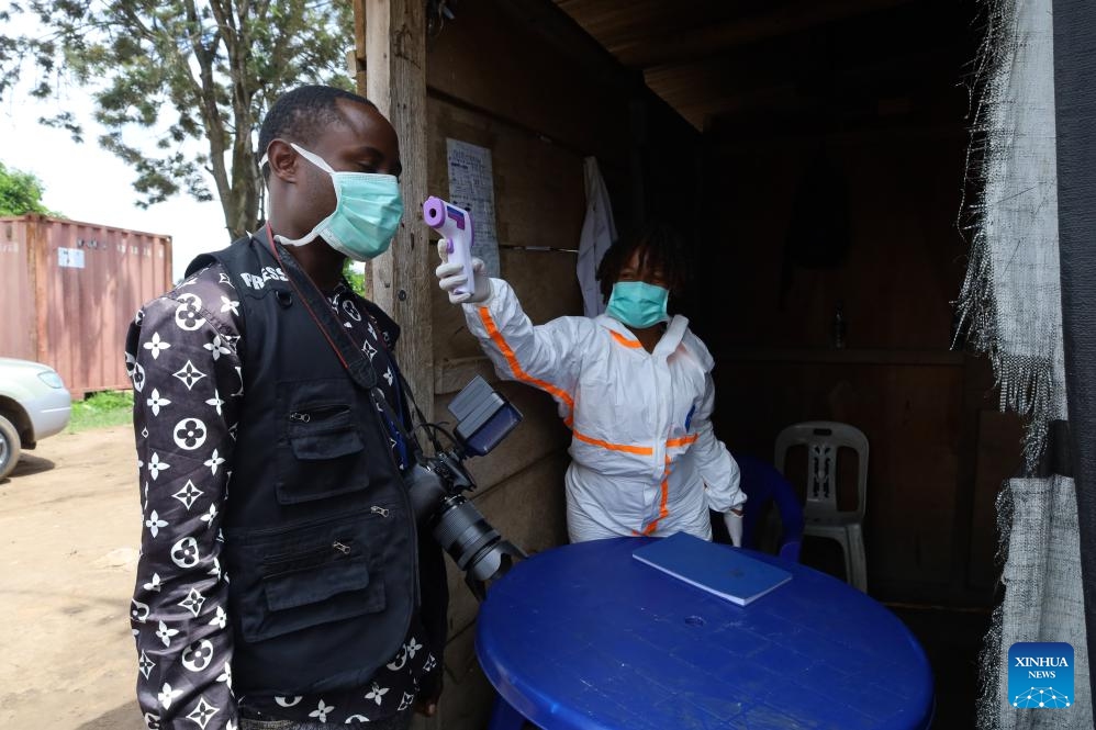 A medical worker checks temperature for a local journalist in Bunia, Ituri Province, the Democratic Republic of the Congo, on May 21, 2026. The outbreak, initially reported in Ituri Province, has now affected North Kivu and South Kivu, while two confirmed cases have also been reported in the neighboring country of Uganda. (Str/Xinhua)