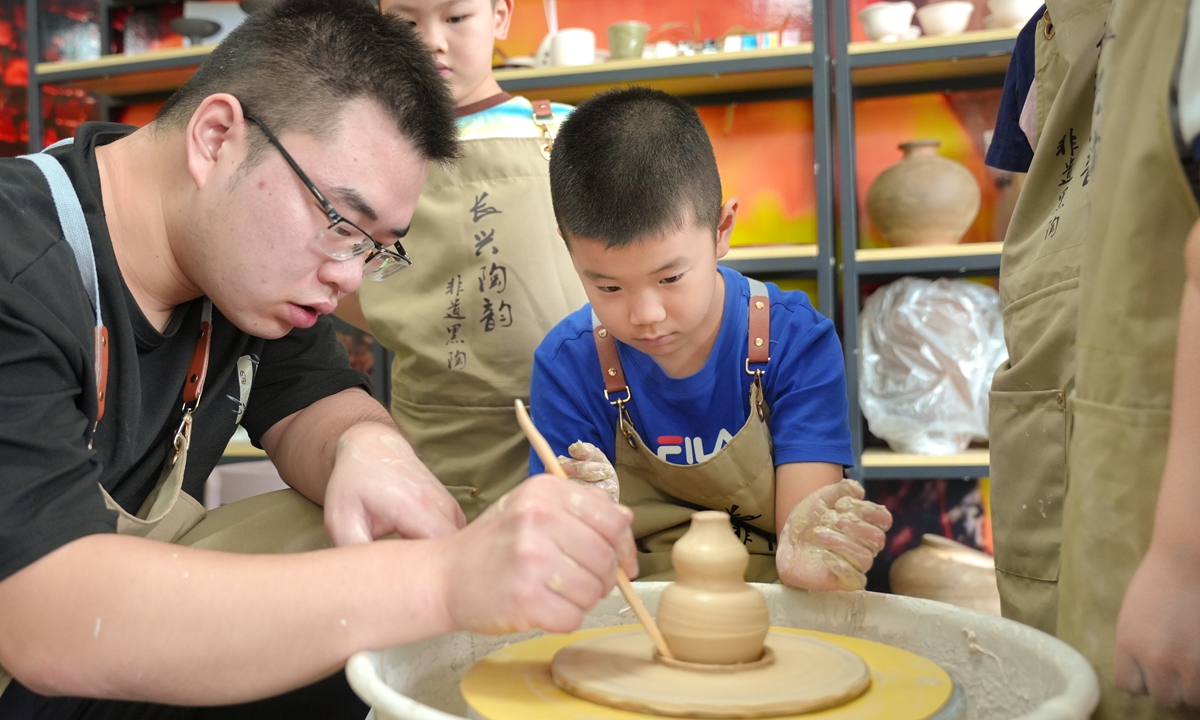 A child tries pottery making, a form of intangible cultural heritage, under the instructions of a young returning entrepreneur in Huzhou, East China's Zhejiang Province on September 20, 2025. Photo: VCG
