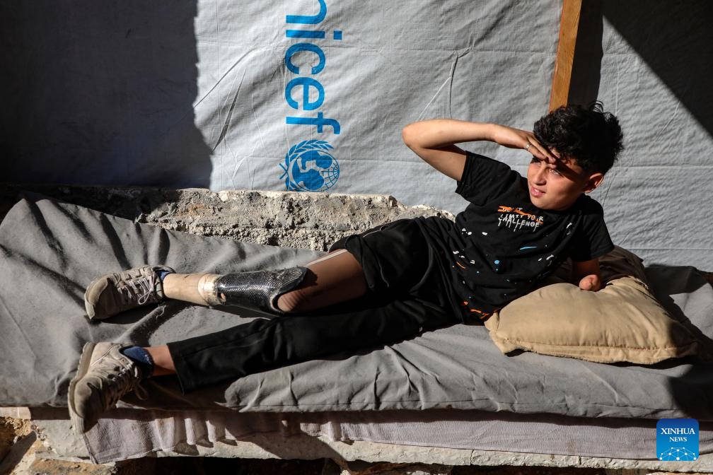 This photo taken on May 22, 2026 shows Akram Sharif al-Fayoumi, a 13-year-old Palestinian teenager, at a temporary tent zone in Gaza City. The boy, from the Shuja'iyya neighborhood of Gaza City, was injured in August of 2024 during an Israeli military operation in eastern Gaza City. He lost his left arm and right leg and remains displaced with his family in western Gaza City. (Photo: Xinhua)