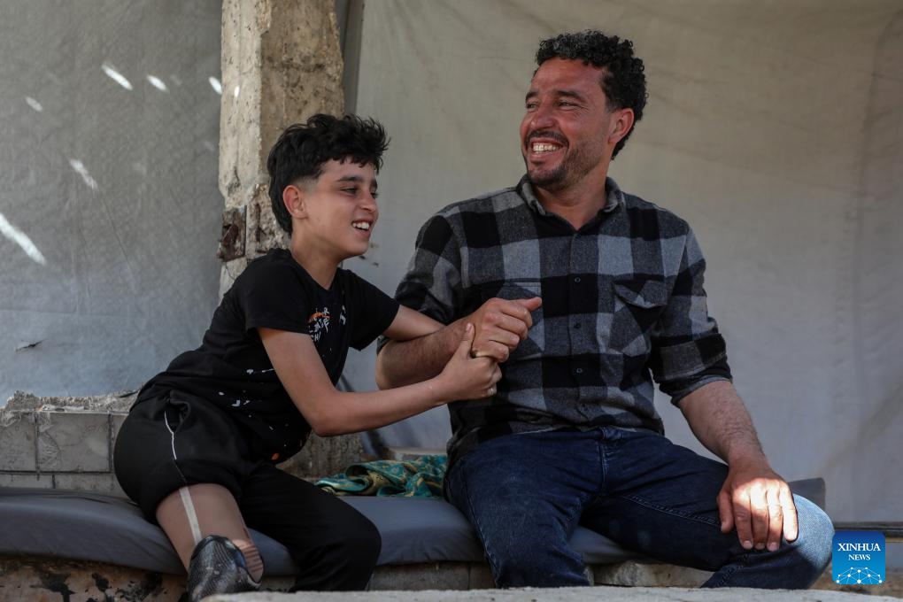 This photo taken on May 22, 2026 shows Akram Sharif al-Fayoumi (L), a 13-year-old Palestinian teenager, at a temporary tent zone in Gaza City. The boy, from the Shuja'iyya neighborhood of Gaza City, was injured in August of 2024 during an Israeli military operation in eastern Gaza City. He lost his left arm and right leg and remains displaced with his family in western Gaza City. (Photo: Xinhua)