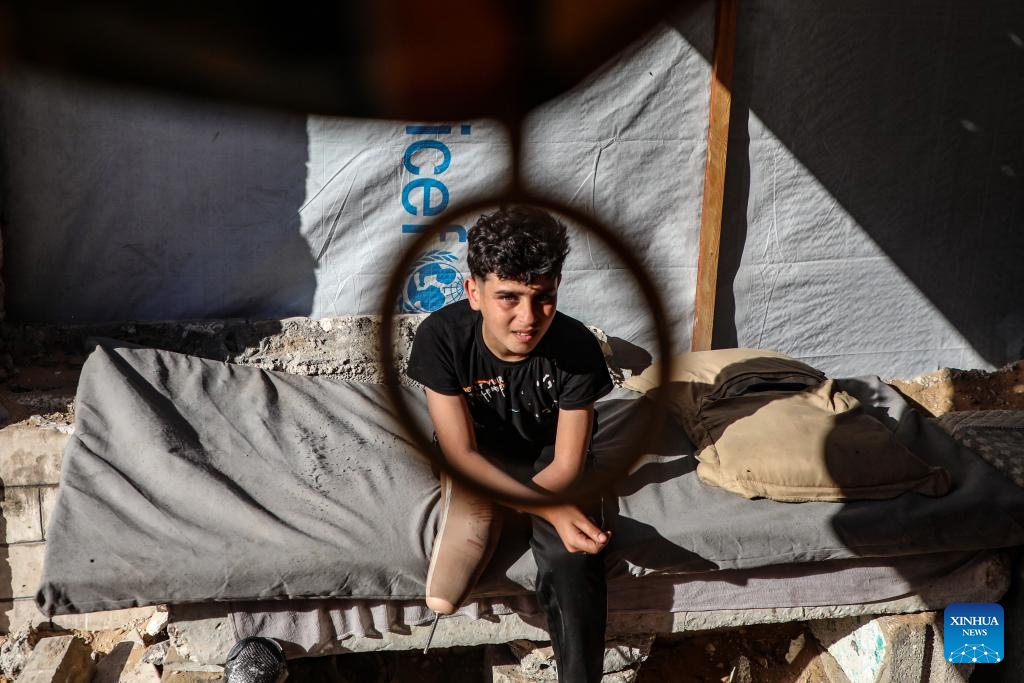 This photo taken on May 22, 2026 shows Akram Sharif al-Fayoumi, a 13-year-old Palestinian teenager, at a temporary tent zone in Gaza City. The boy, from the Shuja'iyya neighborhood of Gaza City, was injured in August of 2024 during an Israeli military operation in eastern Gaza City. He lost his left arm and right leg and remains displaced with his family in western Gaza City. (Photo: Xinhua)