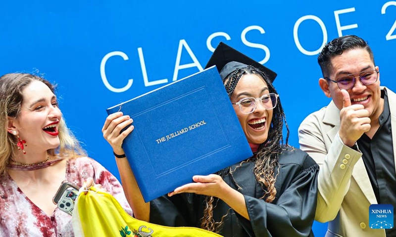 A postgraduate student shows her degree certificate after the commencement at the Tianjin Juilliard School in north China's Tianjin Municipality, May 23, 2026. The Tianjin Juilliard School held the commencement for its postgraduate class of 2026 on Saturday. A total of 42 postgraduate students from 14 countries and regions completed their studies here successfully. (Photo by Du Penghui/Xinhua)