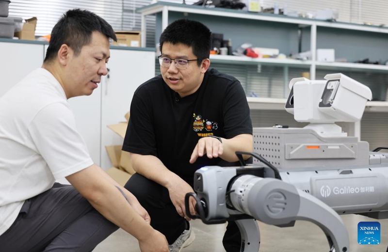 Fu Mingda (R) talks with his colleague at Galileo (Tianjin) Technology Co., Ltd. in Tianjin, north China, May 22, 2026. Thirty-three-year-old Fu Mingda, an electromagnetic engineering designer at Galileo (Tianjin) Technology Co., Ltd., has his sights set on becoming a technical expert in the motor industry. To that end, he has been tackling key challenges in the independent research and development (R&D) of core robotic components.
After earning his master's degree from Shenyang University of Technology in 2018, Fu relocated to Tianjin to focus on the R&D and design of aviation motors. He later joined Galileo, where he was involved in the in-house development of quadruped robot joint modules from the ground up.
At the time, the company relied on externally procured joint modules that were prone to overheating and damage. Furthermore, these outsourced parts could not meet complex performance requirements, such as performing somersaults, climbing slopes, and carrying heavy loads.
In less than six months, Fu achieved a technological breakthrough. Overseeing the process from initial electromagnetic design to supplier development, assembly, and testing, he drove the project through four major iterations and dozens of minor optimizations. Impressively, the very first prototype reached advanced standards in the industry.
Today, fueled by the rapid growth of China's domestic robotics industry, Fu remains busier than ever. He expressed full confidence that, through continued dedication, he will realize his ambition of becoming a leading technical expert in the motor sector. Photo: Xinhua