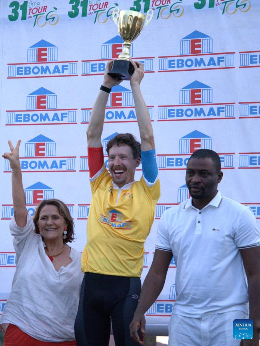 Belgian cyclist Heylen Wannes (C) lifts the trophy in Lome, Togo, May 23, 2026. The 31st International Cycling Tour of Togo concluded Saturday evening in Lome, the Togolese capital. (Xinhua/Si Yuan)