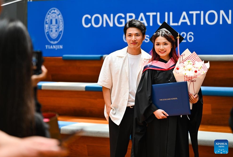 A postgraduate student (R) poses for photos after the commencement at the Tianjin Juilliard School in north China's Tianjin Municipality, May 23, 2026. The Tianjin Juilliard School held the commencement for its postgraduate class of 2026 on Saturday. A total of 42 postgraduate students from 14 countries and regions completed their studies here successfully. (Xinhua/Zhao Zishuo)