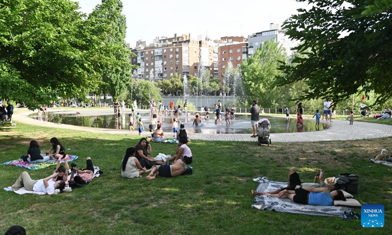People cool off in the water amid heat wave at a park in Madrid, Spain, May 24, 2026. (Photo by Gustavo Valiente/Xinhua)