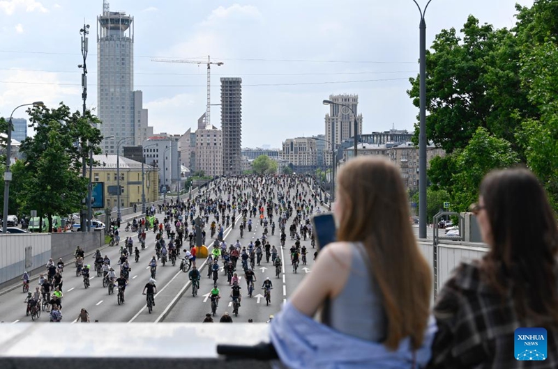 Women watch people riding bicycles during a spring bicycle festival in Moscow, Russia, May 24, 2026. The spring bicycle festival aimed to promote an eco-friendly and healthy lifestyle. (Photo by Alexander Zemlianichenko Jr/Xinhua)