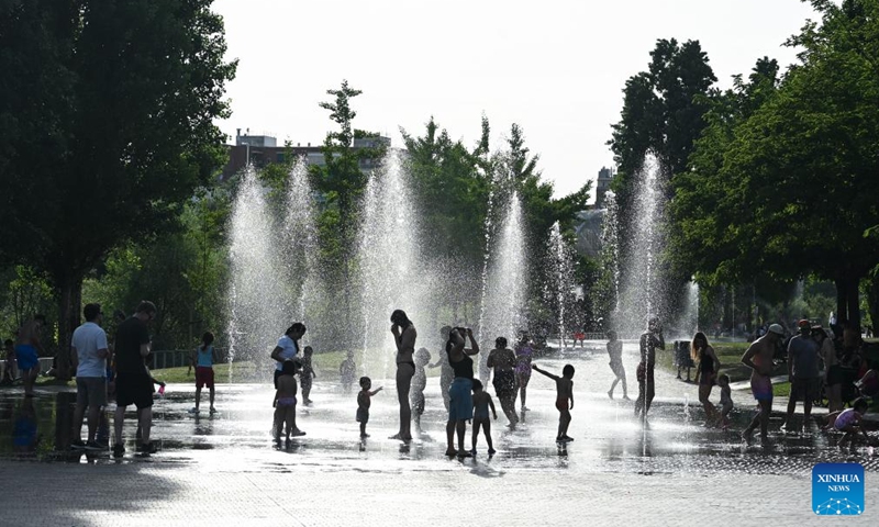 People cool off in the water amid heat wave at a park in Madrid, Spain, May 24, 2026. (Photo by Gustavo Valiente/Xinhua)