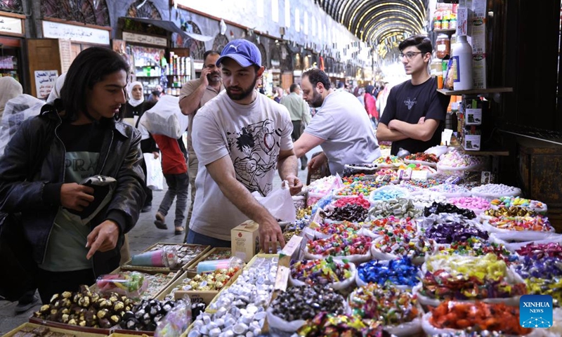 People shop for sweets ahead of the Muslim festival of Eid al-Adha, or the Feast of Sacrifice, in Damascus, Syria, May 24, 2026. (Photo by Ammar Safarjalani/Xinhua)