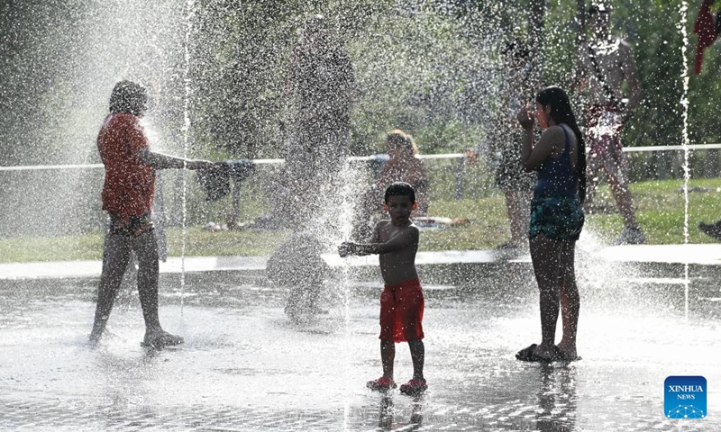 People cool off in the water amid heat wave at a park in Madrid, Spain, May 24, 2026. (Photo by Gustavo Valiente/Xinhua)