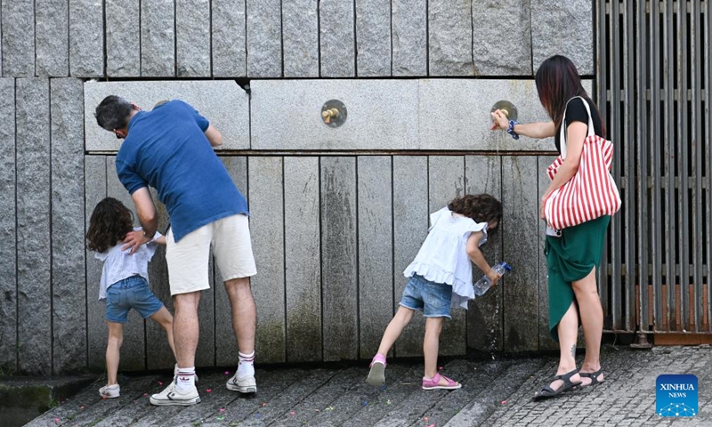 People cool off with water amid heat wave in Madrid, Spain, May 24, 2026. (Photo by Gustavo Valiente/Xinhua)