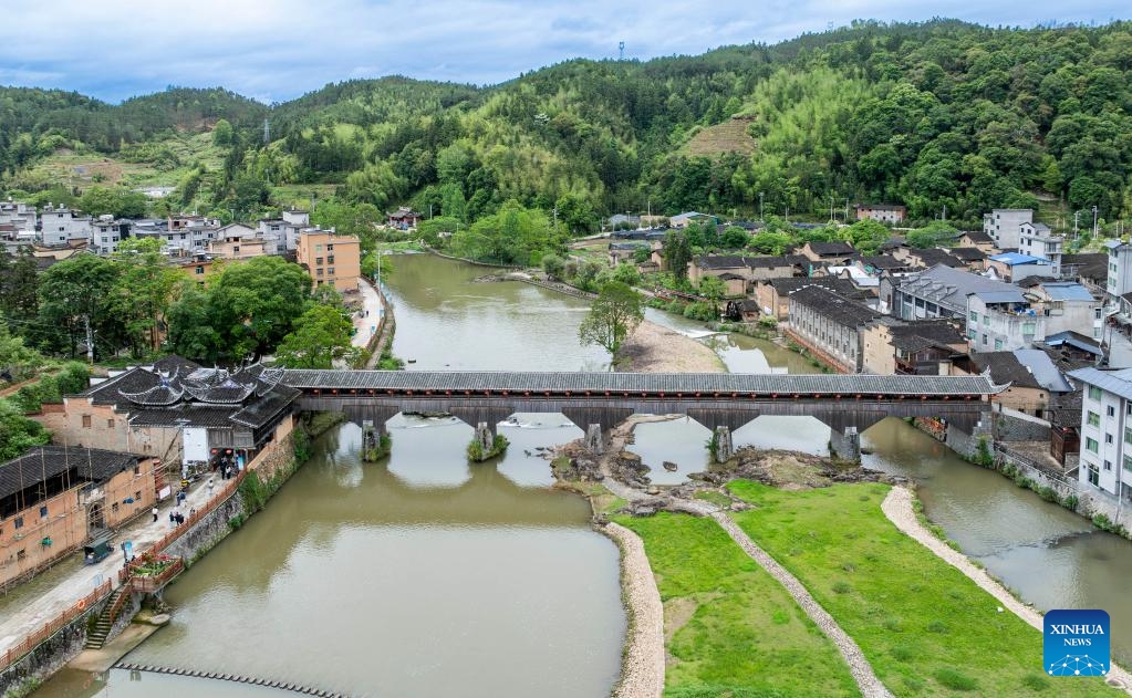 This drone photo taken on May 15, 2026 shows Wan'an Bridge in Pingnan County of Ningde City, southeast China's Fujian Province. The wooden-roofed arch bridge is an ancient and unique structure characterized by a corridor built atop a bridge spanning a river. It reflects the craftsmanship of ancient builders who joined wood into an arch without using nails or metal parts. (Photo: Xinhua)
