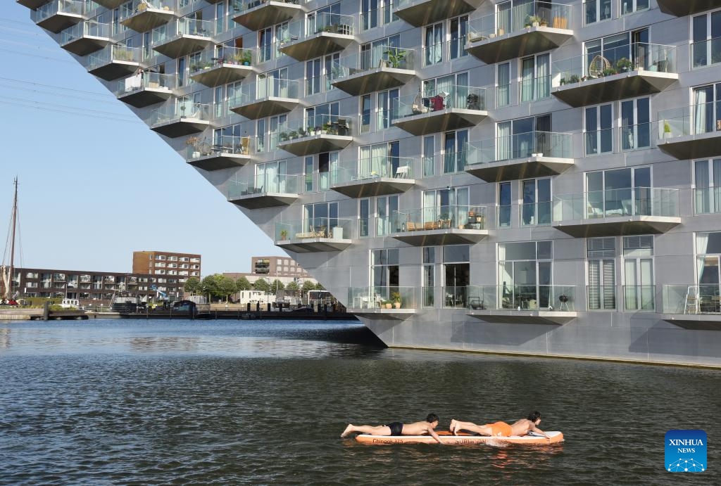 This photo taken on May 26, 2026 shows a view of Sluishuis in Amsterdam, the Netherlands. Sluishuis is a landmark residential building in Amsterdam. Completed in 2022, the building is known for its unique geometric design, with one corner rising upward to create a large opening over the water. (Photo: Xinhua)