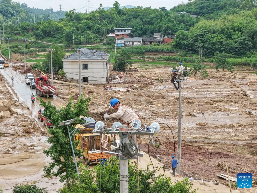 A drone photo taken on May 26, 2026 shows staff members of State Grid Chongqing Yongchuan Power Supply Company repairing power supply lines at Anxi Village of Yongchuan District, southwest China's Chongqing Municipality, May 26, 2026. From Saturday night to early Sunday morning, a sudden and extreme catastrophic rainstorm struck Yongchuan, triggering flash floods and geological disasters in multiple areas of this district. (Photo: Xinhua)