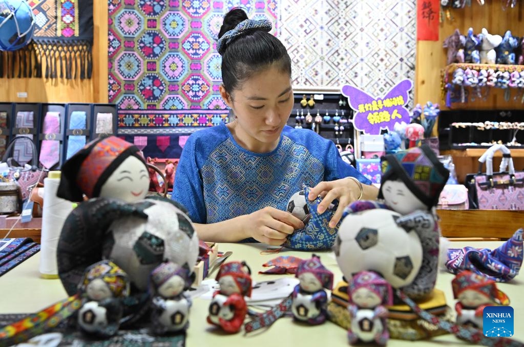 Fan Lihua, an inheritor of Zhuang brocade weaving technique, makes handicrafts of Zhuang brocade at a studio in Nanning, south China's Guangxi Zhuang Autonomous Region, May 26, 2026. Known for its vibrant colors and auspicious patterns like dragons and phoenixes, Zhuang brocade is one of the four famous brocades in China. In 2006, Zhuang brocade weaving skill, a craft dating back to the Han Dynasty (202 BC-220 AD), was included in the first batch of national intangible cultural heritage list. (Photo: Xinhua)