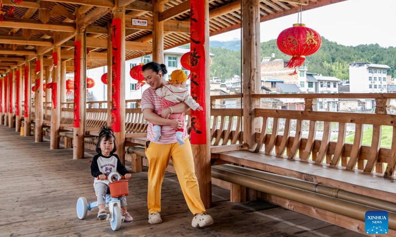 Locals take a rest on Wan'an Bridge in Pingnan County of Ningde City, southeast China's Fujian Province, May 15, 2026. The wooden-roofed arch bridge is an ancient and unique structure characterized by a corridor built atop a bridge spanning a river. It reflects the craftsmanship of ancient builders who joined wood into an arch without using nails or metal parts. (Photo: Xinhua)