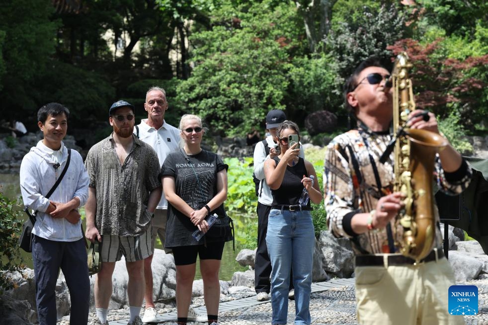 Liu Lichao (1st L) leads his clients to visit Fuxing Park in east China's Shanghai, May 16, 2026. (Photo: Xinhua)