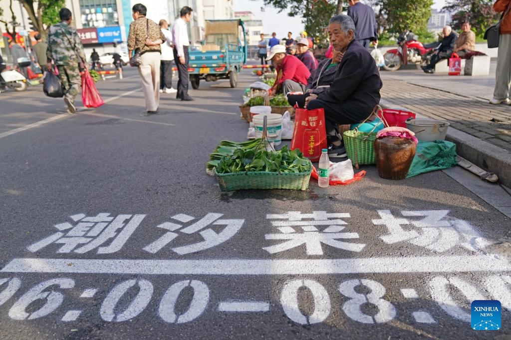 Farmers sell vegetables at a roadside tidal market in Chaisang District of Jiujiang, east China's Jiangxi Province, May 12, 2026. Chaisang District in Jiujiang has found a clever way to tackle the classic conflict between street vendors and morning commuters by launching a flexible tidal market system. Under the system, vendors can use specific roadside areas from 6 a.m. to 8 a.m. without paying any charge, while keeping the streets clear for regular traffic during rush hours. (Photo: Xinhua)