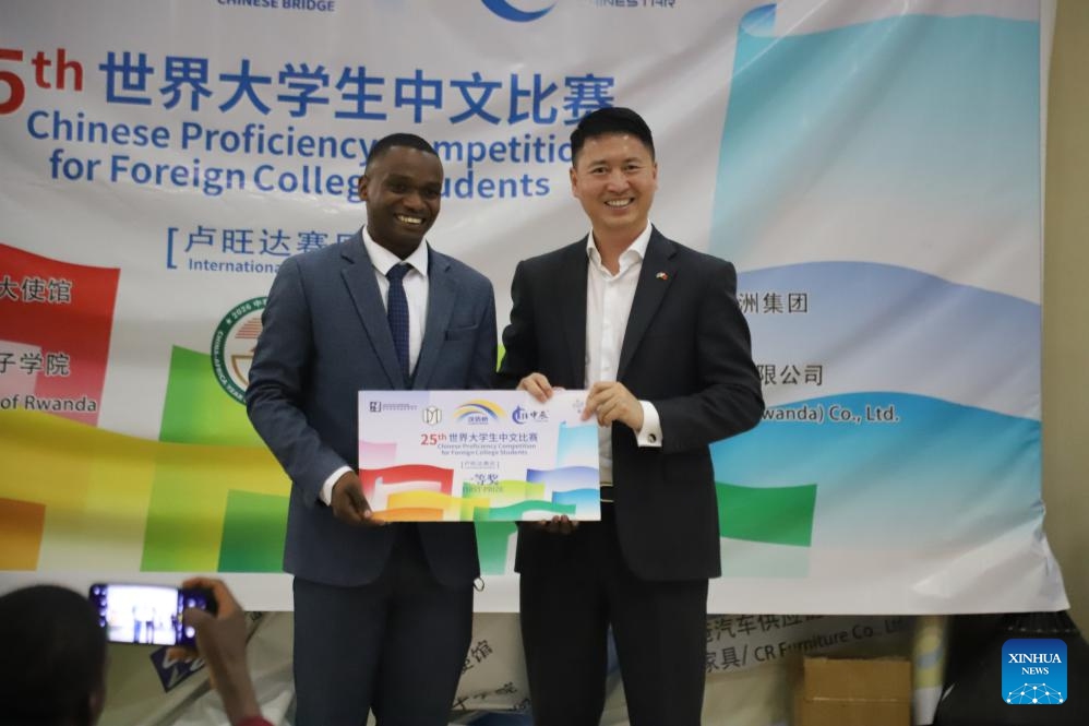 Nkurunziza Tharcisse, the winner of Rwandan final of the 2026 Chinese Bridge Chinese Proficiency Competition for Foreign College Students, poses for photos with Gao Wenqi, Chinese ambassador to Rwanda, in Kigali, Rwanda, May 24, 2026. (Photo: Xinhua)

