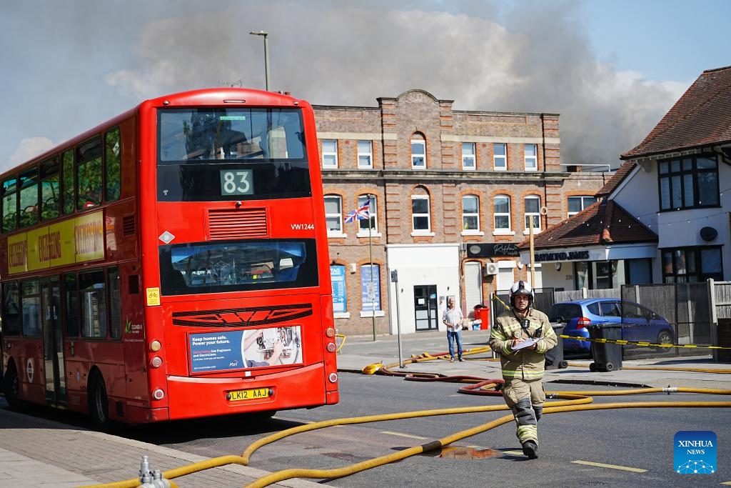 A firefighter is seen as police cordon off the scene after a fire broke out at a supermarket in Golders Green, London, Britain, May 27, 2026. A large fire broke out at a supermarket early Wednesday in Golders Green, an area in northwest London known for its large Jewish community, prompting a major emergency response and road closures, according to the London Fire Brigade. (Photo: Xinhua)