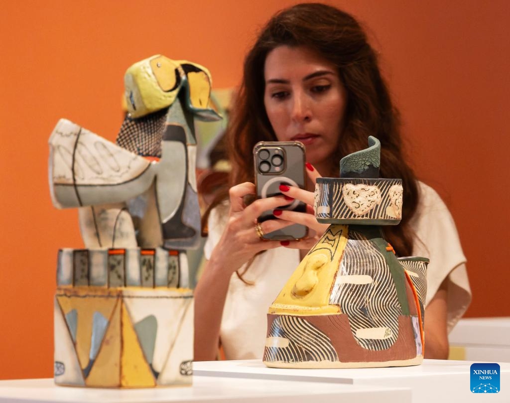 A woman films artworks during the media preview of the International Ceramic Art Fair 2026 at the Gardiner Museum in Toronto, Canada, May 27, 2026. Featuring innovations and contemporary trends in ceramic art, this biennial exhibition opens to the public from May 28 to August 16. (Photo: Xinhua)
