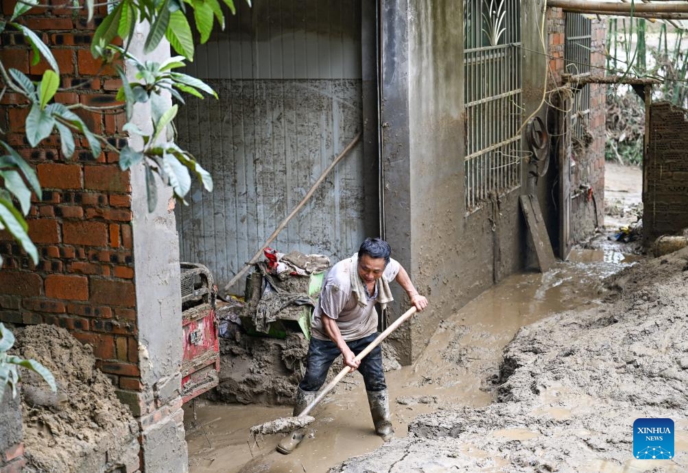 A villager cleans up silt-covered livestock enclosure at Daqiao Village of Yongchuan District, southwest China's Chongqing Municipality, May 26, 2026. From Saturday night to early Sunday morning, a sudden and extreme catastrophic rainstorm struck Yongchuan, triggering flash floods and geological disasters in multiple areas of this district. (Photo: Xinhua)