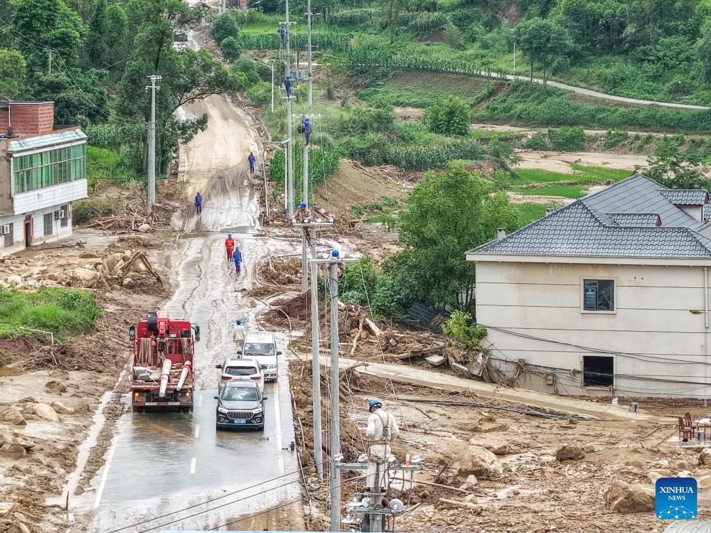 A drone photo taken on May 26, 2026 shows staff members of State Grid Chongqing Yongchuan Power Supply Company repairing power supply lines at Anxi Village of Yongchuan District, southwest China's Chongqing Municipality, May 26, 2026. From Saturday night to early Sunday morning, a sudden and extreme catastrophic rainstorm struck Yongchuan, triggering flash floods and geological disasters in multiple areas of this district. (Photo: Xinhua)