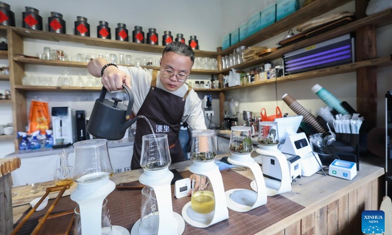 Tan Zaiheng, a young entrepreneur, prepares tea for customers at a tea culture experience space in Huanlou Village, Huzhou City, east China's Zhejiang Province, May 27, 2026. Taking the youth entrepreneurship platform as a core link, Huanlou Village has developed a variety of cultural and tourism scenarios including tea culture experience spaces, outdoor camps, local specialty catering outlets, and parent-child interaction programs in recent years. (Photo: Xinhua)